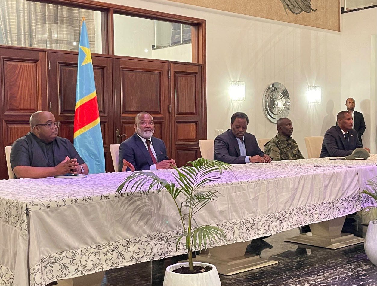 Plusieurs responsables réunis autour d’une table devant le drapeau de la RDC